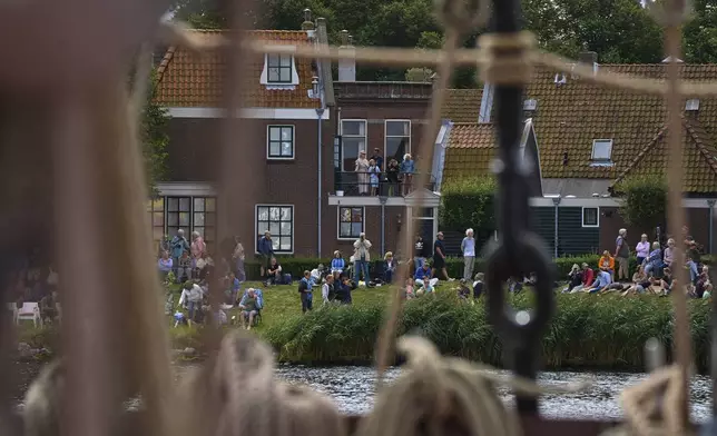 Spectators watch hundreds of tall ships sail into the Dutch capital's harbor for the 10th edition of SAIL, in Amsterdam, Netherlands, Wednesday, Aug. 20, 2025. (AP Photo/Peter Dejong)