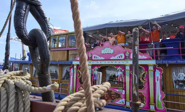 People dance as hundreds of tall ships sailed into the Dutch capital's harbor for the 10th edition of SAIL, in Amsterdam, Netherlands, Wednesday, Aug. 20, 2025. (AP Photo/Peter Dejong)
