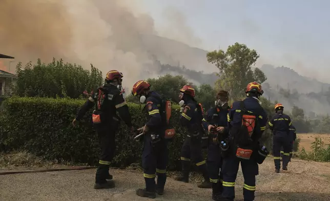 Firefighters prepare to control the wildfire in Vounteni, on the outskirts of Patras, western Greece, Wednesday, Aug, 13, 2025. (AP Photo/Thanassis Stavrakis)