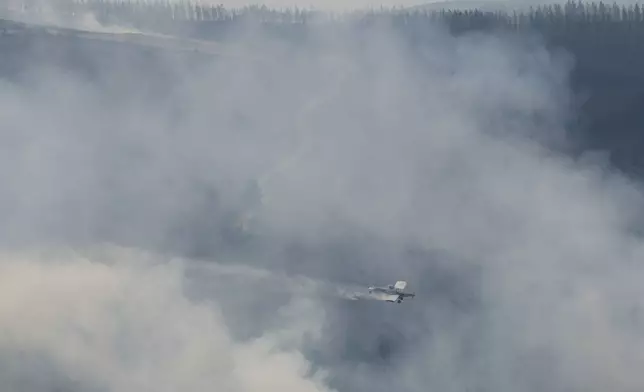 A seaplane drops water on a forest fire in Maceda, northwestern Spain, Wednesday, Aug. 13, 2025. (AP Photo/Lalo Villar)