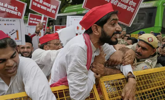 Various opposition parties lawmakers try to break a police barricade during a protest calling for the rollback of a controversial revision of the voter list in one of the country’s poorest states where key elections are scheduled in November, in New Delhi, India, Monday, Aug. 11, 2025. (AP Photo/Manish Swarup)