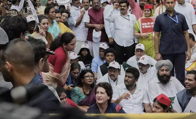Congress party leader Priyanka Gandhi Vadra , center bottom, sits on the road with other parties lawmakers during a protest calling for the rollback of a controversial revision of the voter list in one of the country’s poorest states where key elections are scheduled in November, in New Delhi, India, Monday, Aug. 11, 2025. (AP Photo/Manish Swarup)