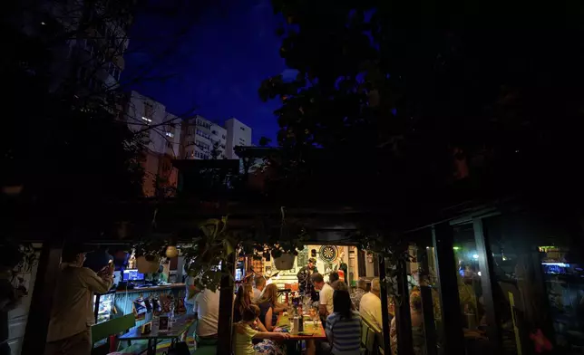 Tudor Lakatos, who goes by the stage name Elvis Rromano, performs with the Taraful Frunzelor band at the Terasa Florilor restaurant, in Bucharest, Romania, Friday, June 20, 2025. (AP Photo/Andreea Alexandru)