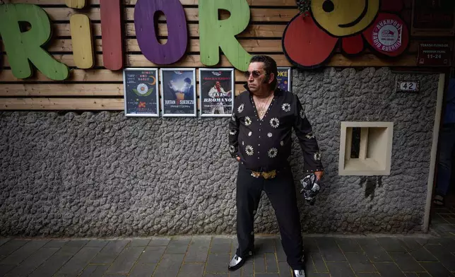 Tudor Lakatos, who goes by the stage name Elvis Rromano, poses outside the Terasa Florilor restaurant before a performance in Bucharest, Romania, Friday, June 20, 2025. (AP Photo/Andreea Alexandru)