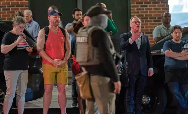 Residents of the area yell at agents of the Department of Homeland Security Investigations as they join Washington Metropolitan Police Department officers to conduct traffic checks at a checkpoint along 14th Street in northwest Washington, Wednesday, Aug. 13, 2025, in Washington. (AP Photo/Jose Luis Magana)
