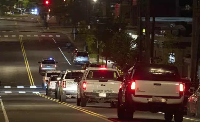 Law enforcement agents with U.S. Customs and Border Protection as well as Metropolitan Police drive along Kennedy Street NW in a caravan, in the early morning of Wednesday, Aug. 13, 2025, in the Petworth neighborhood of Washington. (AP Photo/Jacquelyn Martin)