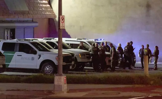Agents with U.S. Customs and Border Protection as well as Metropolitan Police wait in a parking lot before driving along Kennedy Street NW in a caravan, in the early morning of Wednesday, Aug. 13, 2025, in northwest Washington. (AP Photo/Jacquelyn Martin)