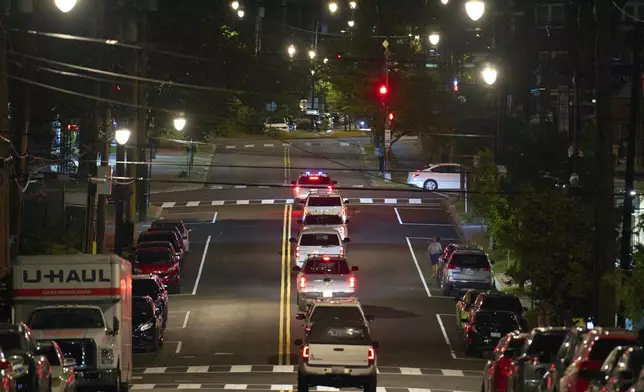 Vehicles with law enforcement agents from the U.S. Customs and Border Protection as well as Metropolitan Police drive along Kennedy Street NW, in the early morning of Wednesday, Aug. 13, 2025, in Petworth neighborhood of Washington. (AP Photo/Jacquelyn Martin)
