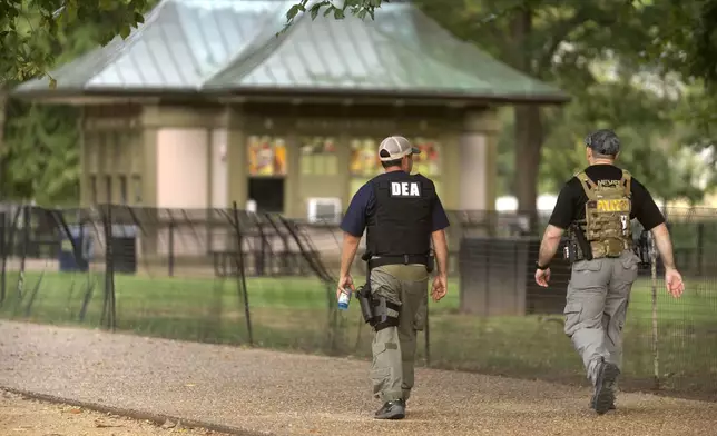 Officers with the Drug Enforcement Administration walk as they patrol along the National Mall Wednesday, Aug. 13, 2025, in Washington. (AP Photo/Mark Schiefelbein)