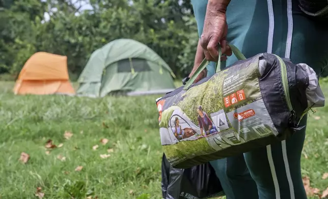 Ms. Jay, of Washington, who lost her job and is living what she calls her "Girl Scout life" while saving money by urban camping and looking for work while homeless, packs up her tent and belongings in a small park by Georgetown, Wednesday, Aug. 13, 2025, in Washington, after being warned by an aid organization that tents are being removed. "Last night was so scary," says Ms. Jay, "I don't want to be the one to wait until the last moment and then have to rush out." (AP Photo/Jacquelyn Martin)