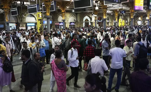 Commuters stranded at Chhatrapati Shivaji Maharaj Terminus after heavy rains disrupted rail services in Mumbai, Tuesday, Aug. 19, 2025. (AP Photo/Rajanish Kakade)