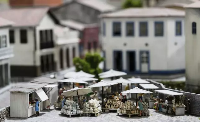 Vendors are depicted in a miniature version of of Ouro Preto, Brazil, at a workshop in Pilar, Argentina, Wednesday, June 25, 2025. (AP Photo/Natacha Pisarenko)