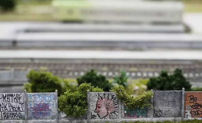 Miniature graffiti at a workshop in Pilar, Argentina, Wednesday, June 25, 2025, is visible on a scene made to look like Mairinque, Brazil. (AP Photo/Natacha Pisarenko)