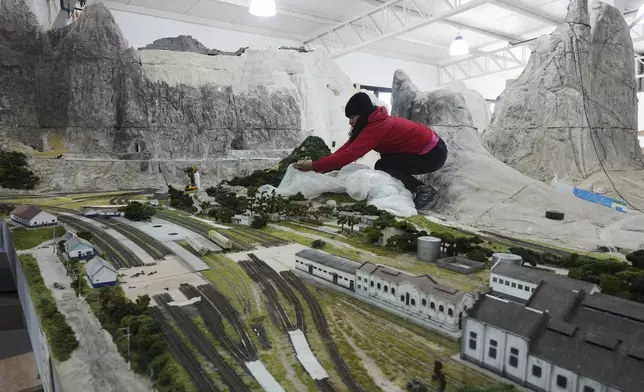 Workers in Pilar, Argentina, Wednesday, June 25, 2025, construct a miniature version of Mairinque, Brazil. (AP Photo/Natacha Pisarenko)