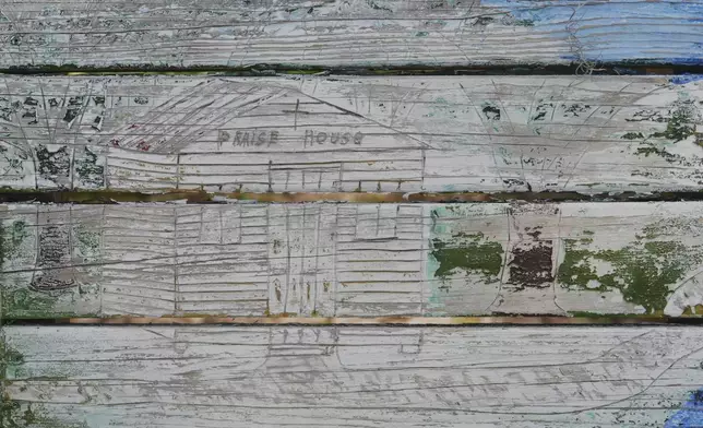A bench with wood burning designs paying homage to praise houses that once served as a place of worship for the enslaved, and later, for generations of free Black Americans sits outside the Tabernacle Baptist Church in Beaufort, South Carolina, Saturday, July 19, 2025. (AP Photo/Luis Andres Henao)