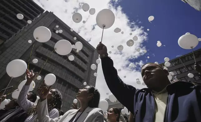 Employees of the attorney general's office release balloons during a ceremony to honor presidential hopeful and opposition Sen. Miguel Uribe, after his death more than two months after he was shot during a political rally, in Bogota, Colombia, Monday, Aug. 11, 2025. (AP Photo/Ivan Valencia)