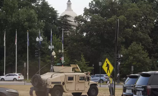 With the U.S. Capitol dome in the distance, members of the South Carolina National Guard sit positioned outside of Union Station in Washington, Sunday, Aug. 24, 2025. (AP Photo/Rod Lamkey, Jr.)