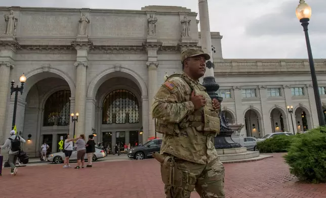 An armed member of the South Carolina National Guard walks across the plaza outside of Union Station in Washington, Sunday, Aug. 24, 2025. (AP Photo/Rod Lamkey, Jr.)