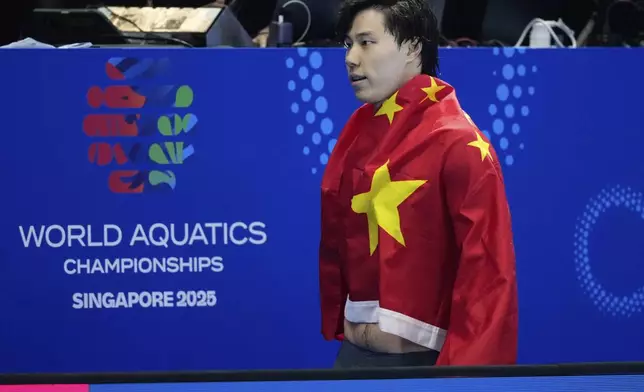 Qin Haiyang of China celebrates after winning gold medal in the men's 200-meter breaststroke final at the World Aquatics Championships in Singapore, Friday, Aug.1, 2025. (AP Photo/Vincent Thian)