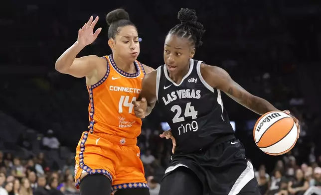 Las Vegas Aces guard Jewell Loyd (24) drives against Connecticut Sun guard Bria Hartley (14) during the first half of a WNBA basketball game Sunday, Aug. 10, 2025, in Las Vegas. (Steve Marcus/Las Vegas Sun via AP)