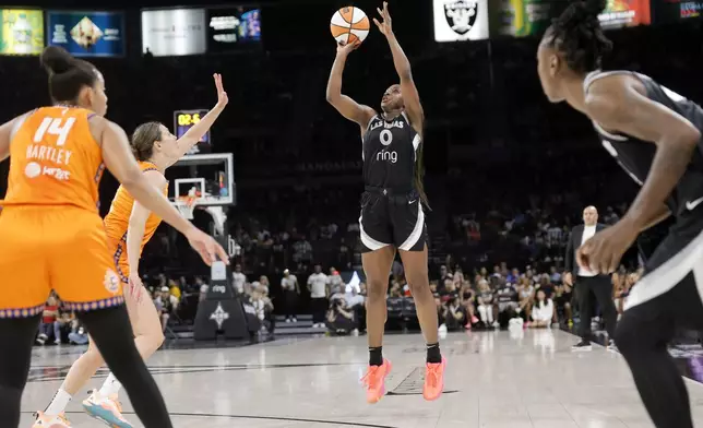 Las Vegas Aces guard Jackie Young (0) goes up to shoot in front of Connecticut Sun guard Bria Hartley (14) and forward Haley Peters, second from left, during the first half of a WNBA basketball game Sunday, Aug. 10, 2025, in Las Vegas. (Steve Marcus/Las Vegas Sun via AP)