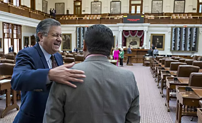 Texas Rep. Richard Peña Raymond, D-Laredo, left, shares a laugh with Rep. John Lujan, R-San Antonio, as they enter the House chambers of the State Capitol at the Texas Capitol, Tuesday, Aug. 5, 2025, in Austin, Texas. (AP Photo/Rodolfo Gonzalez)