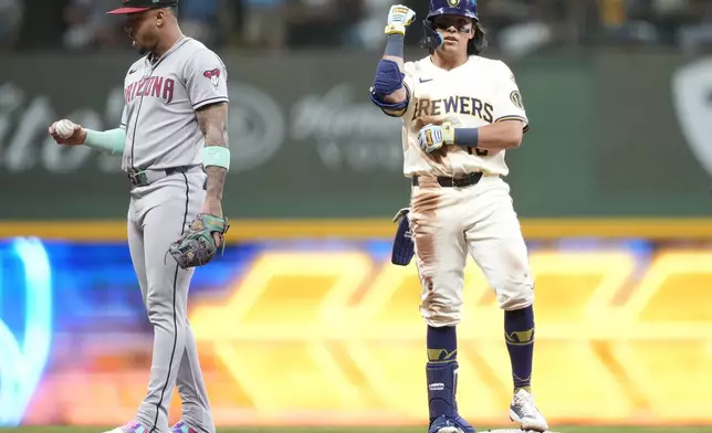 Milwaukee Brewers second baseman Anthony Seigler, right, reacts to hitting a two-run RBI double as Arizona Diamondbacks second baseman Ketel Marte (4) looks at the ball during the third inning of a baseball game, Tuesday, Aug. 26, 2025, in Milwaukee. (AP Photo/Kayla Wolf)