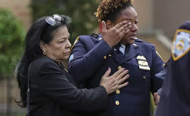 New York Police officer Jackeline Gonzalez, right, reacts as she gathers with other officers outside the Parkchester Jame Masjid mosque for the funeral of officer Didarul Islam, Thursday, July 31, 2025, in New York. (AP Photo/Angelina Katsanis)