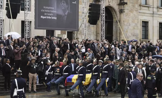 The coffin of presidential hopeful and opposition Sen. Miguel Uribe, who died of gunshot wounds sustained at a political rally, is carried to the cathedral in Bogota, Colombia, Wednesday, Aug. 13, 2025. (AP Photo/Ivan Valencia)