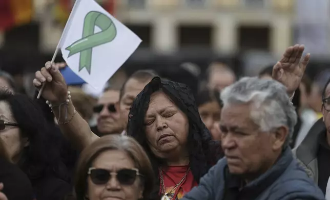 Mourners gather outside the cathedral in Bogota, Colombia, Wednesday, Aug. 13, 2025, during the funeral service for presidential hopeful and opposition Sen. Miguel Uribe, who died from wounds suffered when he was shot at a political rally. (AP Photo/Ivan Valencia)
