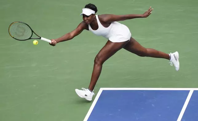 Venus Williams, of the United States, returns a shot to Lyudmyla Kichenok, of the Czech Republic, and Ellen Perez, of Australia, during a first round women's double match of the U.S. Open tennis championships, Thursday, Aug. 28, 2025, in New York. (AP Photo/Yuki Iwamura)
