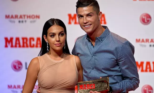 FILE - Juventus soccer player Cristiano Ronaldo poses with his partner, model Georgina Rodriguez in Madrid, July 29, 2019. (AP Photo/Paul White, File)