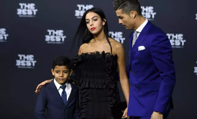 FILE -Portugal's soccer player Cristiano Ronaldo, right, his girlfriend Georgina Rodriguez, center, and his son Ronaldo jr., left, arrive on the green carpet prior during the The Best FIFA Football Awards 2016 ceremony held at the Swiss TV studio in Zurich, Switzerland, Jan. 9, 2017. (Walter Bieri/Keystone via AP, File)