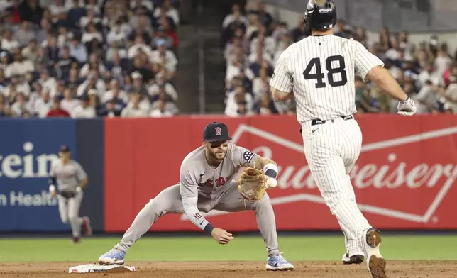 Boston Red Sox shortstop Trevor Story, front left, catches the ball to put out New York Yankees' Paul Goldschmidt, right, at second base during the fourth inning of a baseball game, Thursday, Aug. 21, 2025, in New York. (AP Photo/Pamela Smith)