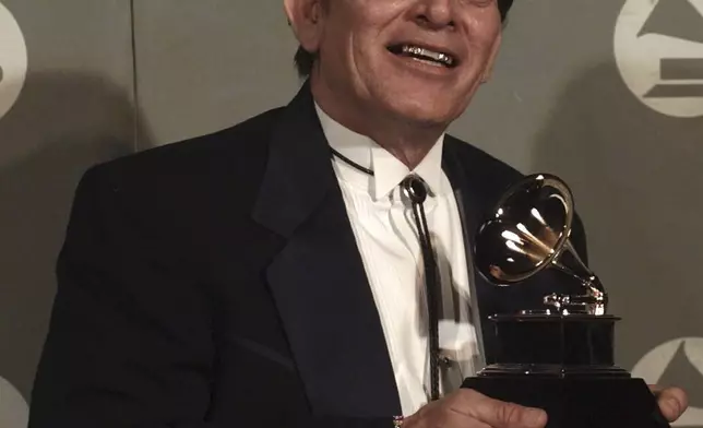 FILE - Flaco Jimenez poses with the Grammy that he won for Best Mexican-American Performance at the 38th annual Grammy Awards at the Shrine Auditorium in Los Angeles, Wednesday, Feb. 28, 1996. (AP Photo/Reed Saxon, File)