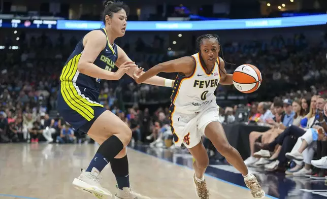 Indiana Fever guard Kelsey Mitchell, right, drives against Dallas Wings center Li Yueru during the first half of a WNBA basketball game Friday, Aug. 1, 2025, in Dallas. (AP Photo/Julio Cortez)