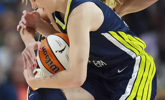 Dallas Wings guard Paige Bueckers, front, collides with Indiana Fever guard Lexie Hull while driving to the basket during the first half of a WNBA basketball game Friday, Aug. 1, 2025, in Dallas. (AP Photo/Julio Cortez)