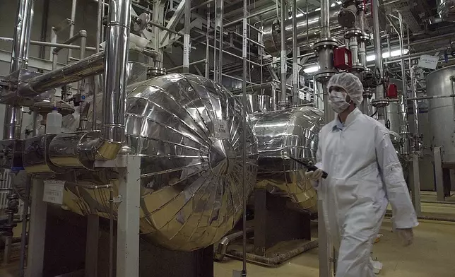 FILE - An Iranian security official in protective clothing walks through part of the Uranium Conversion Facility just outside the Iranian city of Isfahan, March 30, 2005. (AP Photo/Vahid Salemi, File)