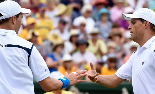 FILE - Mike Bryan, left, and Bob Bryan of the United States shake hands between points while playing against Australia's Lleyton Hewitt and John Peers during their Davis Cup doubles match in Melbourne, Australia, March 5, 2016. (AP Photo/Andrew Brownbill, File)