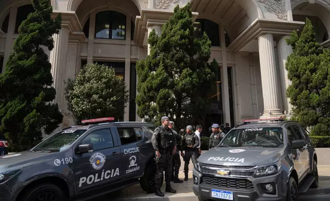 Police stand guard in front of a building during an operation investigating investment funds and the fuel sector, on Avenida Faria Lima, in Sao Paulo, Thursday, Aug. 28, 2025. (AP Photo/Andre Penner)