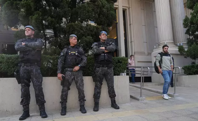 Police officers stand guard in front of a building during an operation investigating investment funds and the fuel sector, on Avenida Faria Lima, in Sao Paulo, Thursday, Aug. 28, 2025. (AP Photo/Andre Penner)