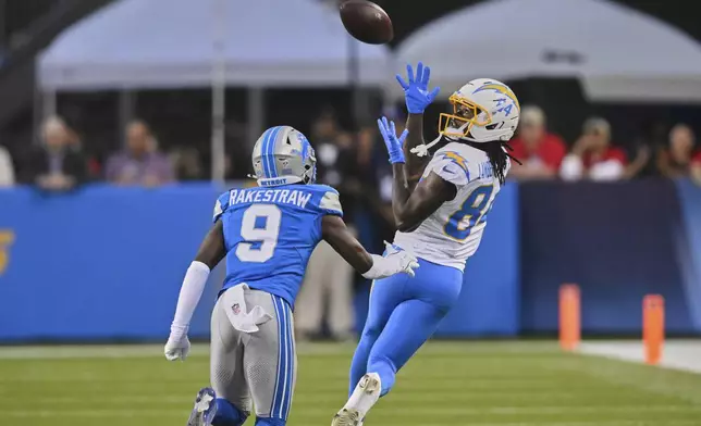 Los Angeles Chargers wide receiver KeAndre Lambert-Smith (84) catches a pass in front of Detroit Lions cornerback Ennis Rakestraw Jr. (9) in the first half of the Pro Football Hall of Fame NFL preseason game Thursday, July 31, 2025, in Canton, Ohio. (AP Photo/David Richard)