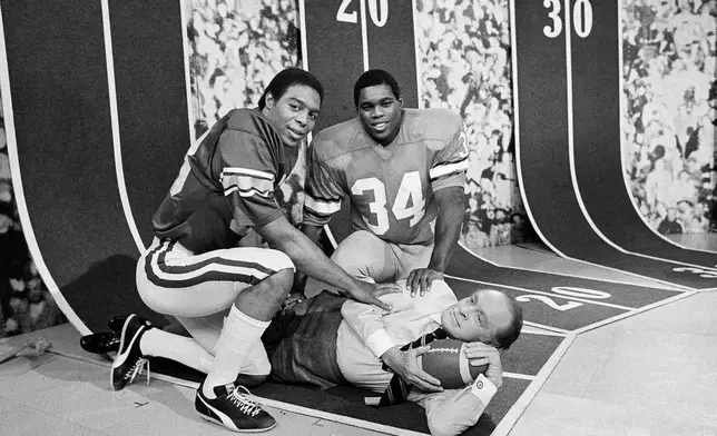 FILE - Heisman Trophy winner Marcus Allen, left, and Heisman runner-up Herschel Walker ham it up with Bob Hope, center, during a break in the taping of Hopes Annual Christmas Special at the NBC Studios, Monday, Dec. 8, 1981, in Burbank, Calif. (AP Photo/Wally Fong)