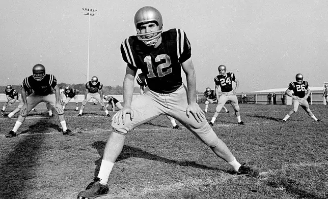 FILE - Navy quarterback Roger Staubach stretches with the rest of the football team in Baltimore, Md., Oct. 22, 1963. (AP Photo/File)