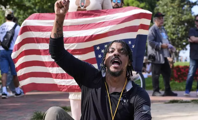 Dionte Carter raises his fist during a protest of President Donald Trump's federal takeover of policing of the District of Columbia, Saturday, Aug. 16, 2025, near the White House in Washington. (AP Photo/Alex Brandon)