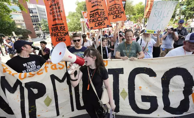 Activists carrying signs march to the White House to protest President Donald Trump's federal takeover of policing of the District of Columbia, Saturday, Aug. 16, 2025, in Washington. (AP Photo/Alex Brandon)