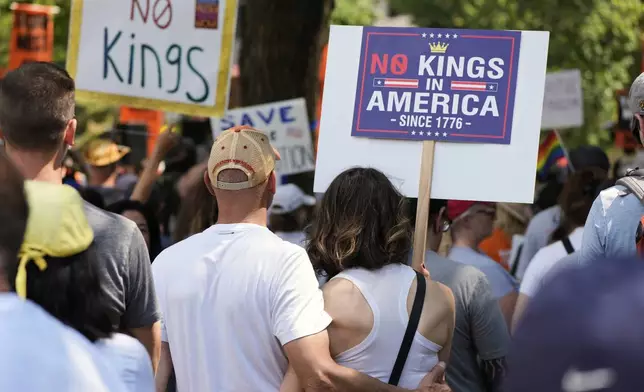 Activists carry signs during a protest against President Donald Trump's federal takeover of policing of the District of Columbia, Saturday, Aug. 16, 2025, in Washington. (AP Photo/Alex Brandon)