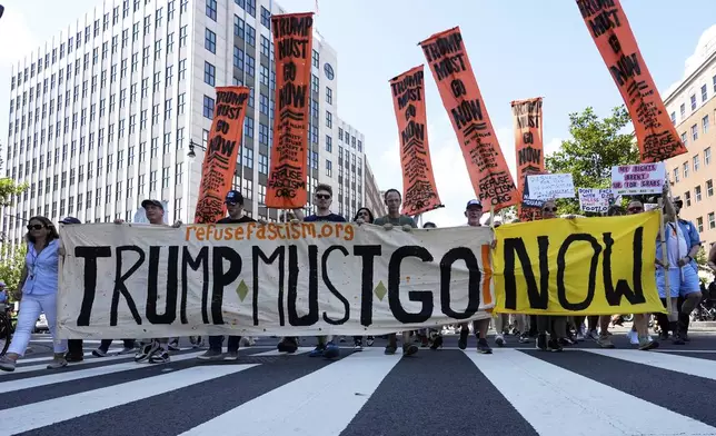 Activists carrying signs march to the White House to protest President Donald Trump's federal takeover of policing of the District of Columbia, Saturday, Aug. 16, 2025, in Washington. (AP Photo/Alex Brandon)