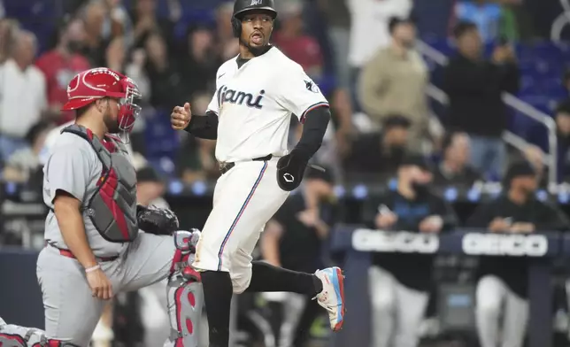 Miami Marlins' Xavier Edwards, right, scores past St. Louis Cardinals catcher Pedro Pages, left, on a triple hit by Jakob Marsee during the fourth inning of a baseball game, Tuesday, Aug. 19, 2025, in Miami. (AP Photo/Lynne Sladky)
