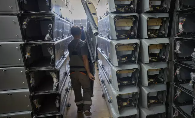 A worker carries part of a combat drone at Fire Point's secret factory in Ukraine on Thursday, Aug. 14, 2025. (AP Photo/Efrem Lukatsky)